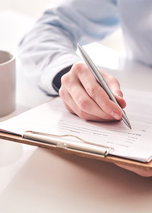 Man holding a pen to a clipboard taking a patients contact information