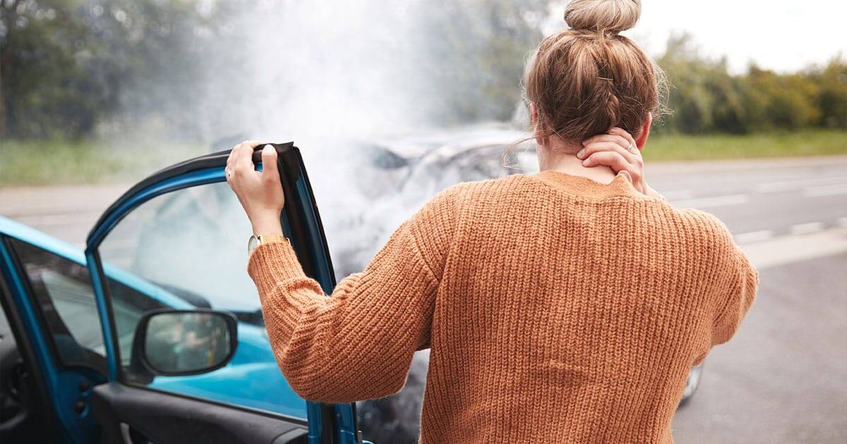 Distracted woman after car accident, emergency roadside assistance, woman holding neck in pain, traffic collision, healthcare emergency.