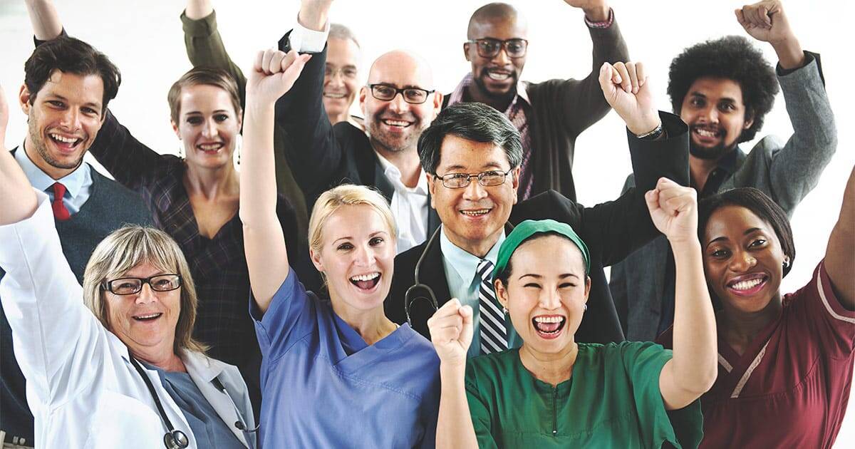 Happy diverse healthcare team celebrating success together.