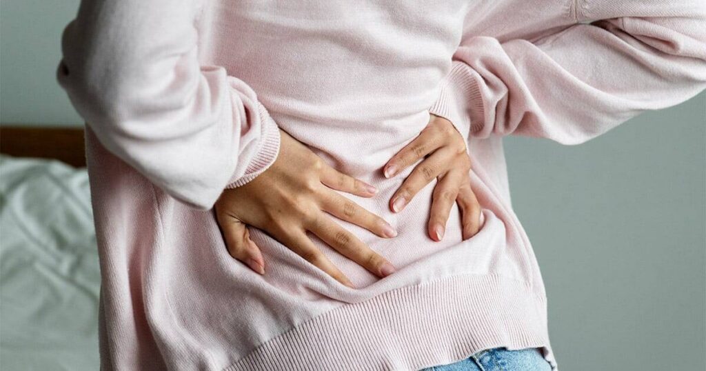 Stomach pain or abdominal discomfort, woman holding her stomach, health issue.