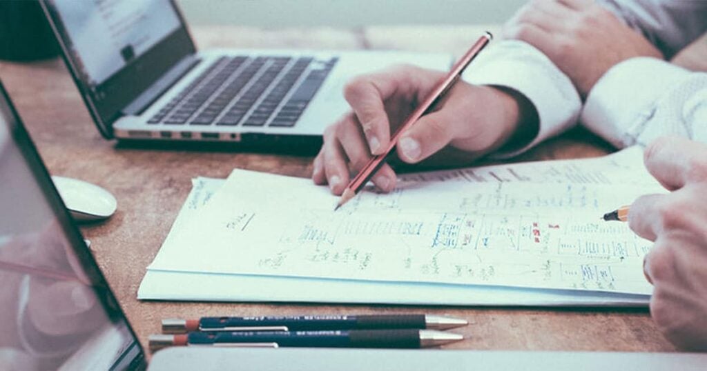 Business professionals discussing educational strategies and advice at a meeting.