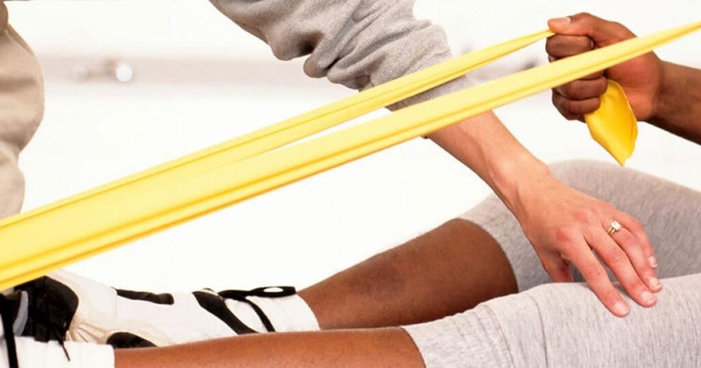 Rehabilitation exercise using resistance bands for recovery and strength building.