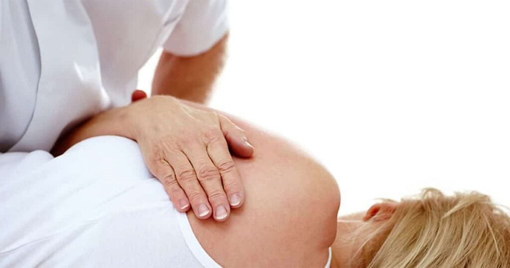 Chiropractor performing spinal manipulation therapy on a patient’s back.