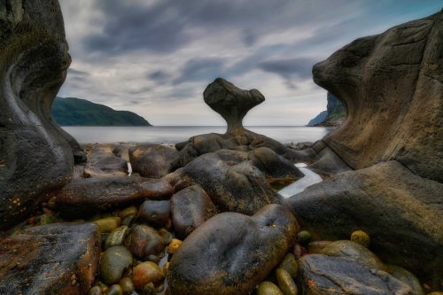 norway, Unusual stone in Atlantic ocean coast. View on Kannesteinen and Kvalheimsvika. Over thousands of years, ocean waves have ground the rock to the special shape it has today. norway, Unusual stone in Atlantic ocean coast. View on Kannesteinen and Kvalheimsvika. Over thousands of years, ocean waves have ground the rock to the special shape it has today.
