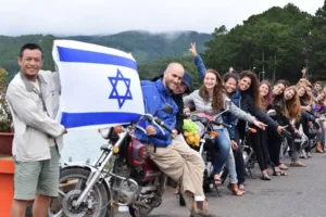 קבוצת מטיילים ישראלים בטיול אופנועים בדלאט עם דגל ישראל – חוויה עם EastCard