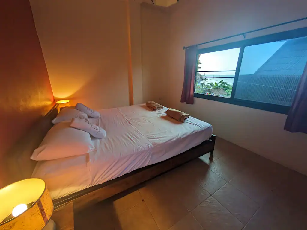 חדר זוגי עם שתי מיטות יחיד ומנורה חמימה ב־Goodtime Diver Guesthouse – איסטקארד