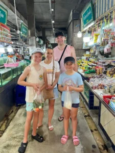 משפחה לומדת לבשל מנות תאילנדיות בשוק המקומי בפוקט – סדנה מהנה