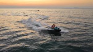 זוג רוכבים על אופנוע ים בזמן שקיעה זהובה בים פאטאיה – איסטקארד