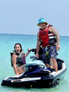 זוג מחייך על אופנוע ים במים רדודים וצלולים בקו לאן – איסטקארד