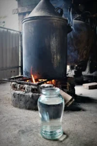 דוד זיקוק יין אורז על אש פתוחה עם צנצנת איסוף