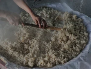 בחישה ידנית של אורז מאודה להכנת יין אורז