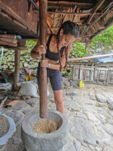 טחינת גרגירים כחלק מביקור בכפר מקומי בטרק טרסות האורז בבנאווי- איסט קארד