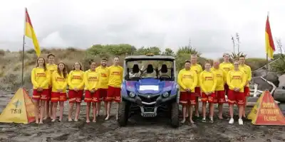 Team of East End Surf Life Saving Club members in yellow uniforms, ready for beach rescue training.