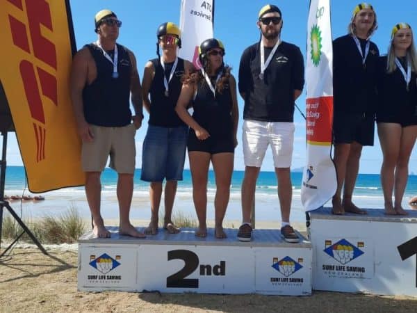 Second line: Surf Life Saving Club team on podium with medals at beach event.