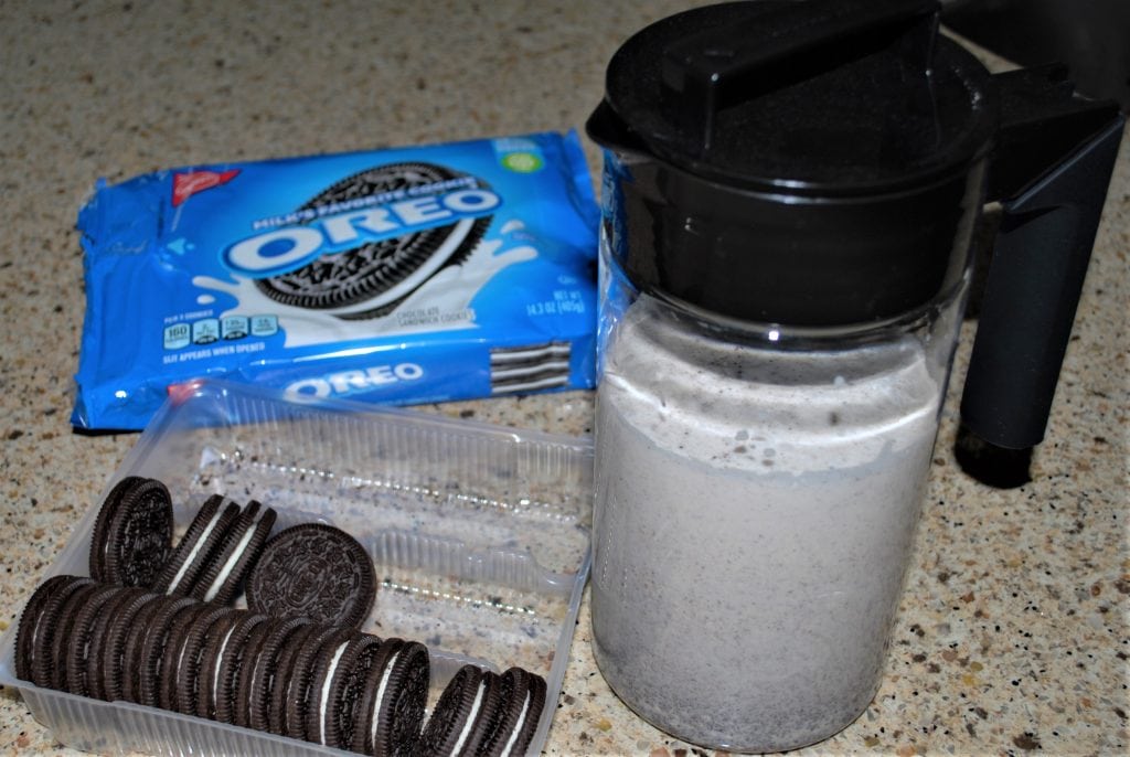 Oreo Cookie Shooters in a carafe alongside Oreo Cookies