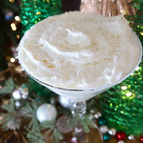 Snowball Martini Garnished with Whipped Cream and Coconut Flakes