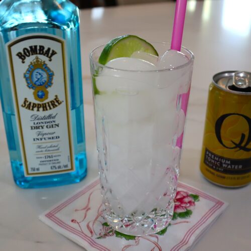 Gin & Tonic with a slice of lime and a pink straw