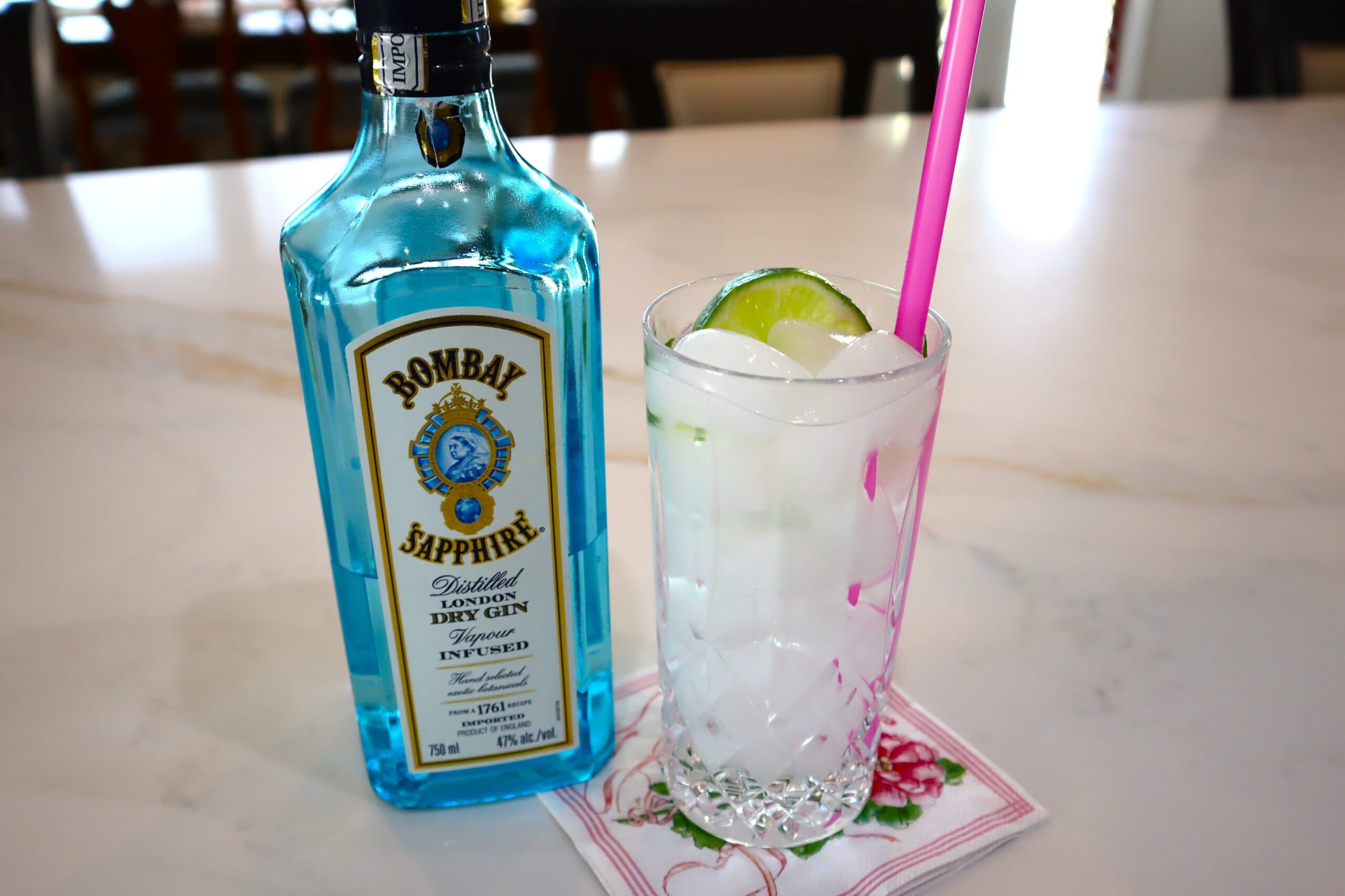 Gin & Tonic with a slice of lime and a pink straw