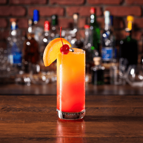 Tequila Sunrise with a slice of orange and a cherry