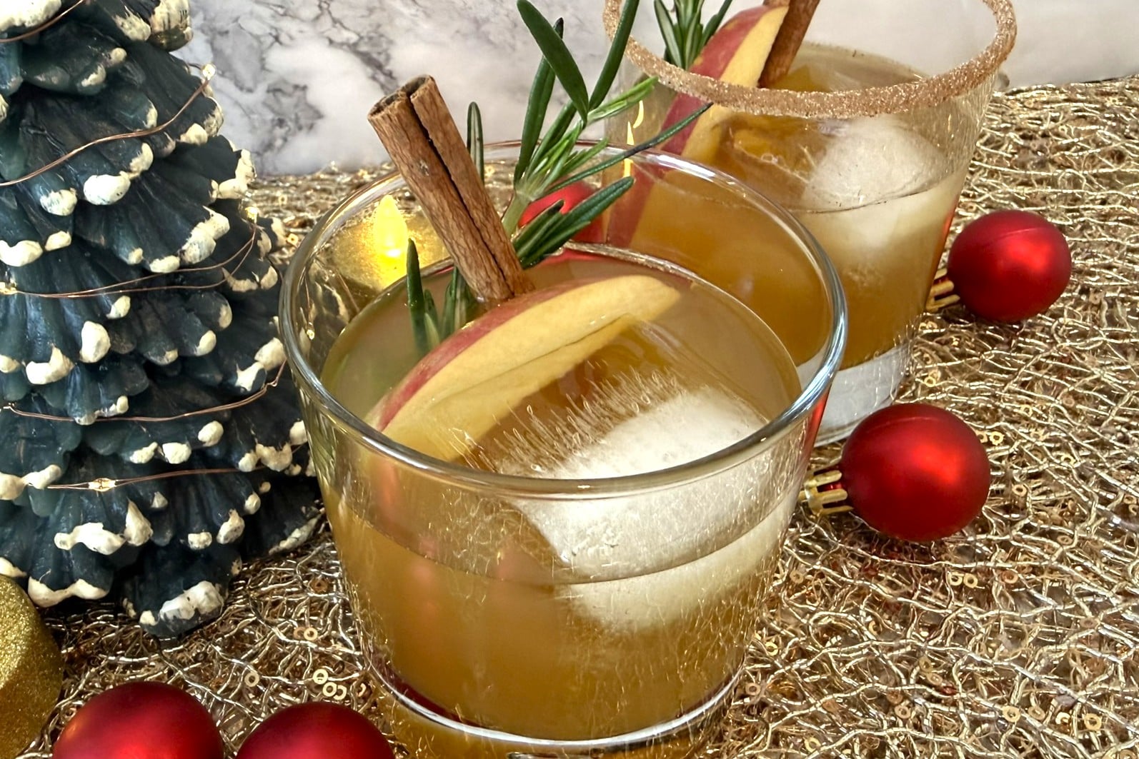 Festive apple cider bourbon cocktail with cinnamon and apple slices for Christmas.