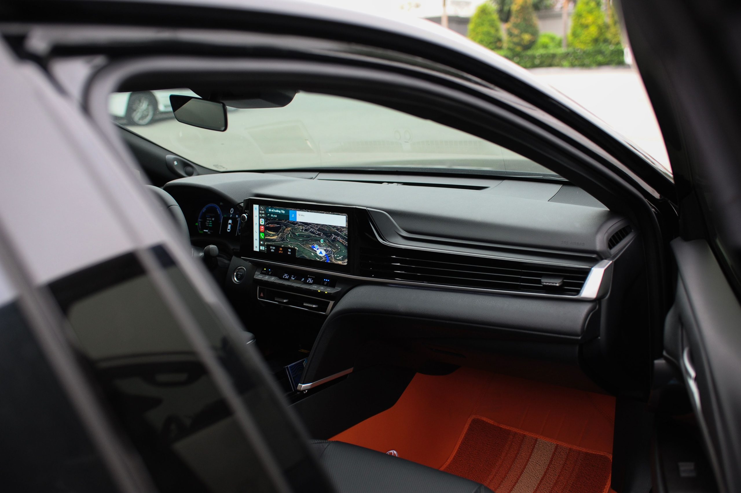 Close-up of a car dashboard with digital display and steering wheel.