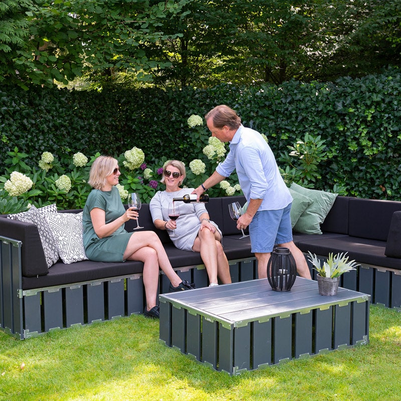 Elegant outdoor lounge furniture set by EJH Distribution in a lush garden setting.