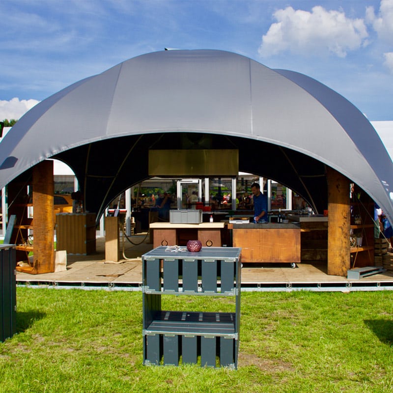 Portable event tent with wooden counter and outdoor hospitality setup for catering or food service.