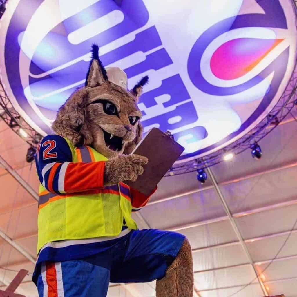 Viking mascot reading a clipboard at an event in a sports arena.