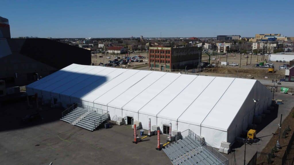 Large white event tent setup for corporate or event use in an urban area.