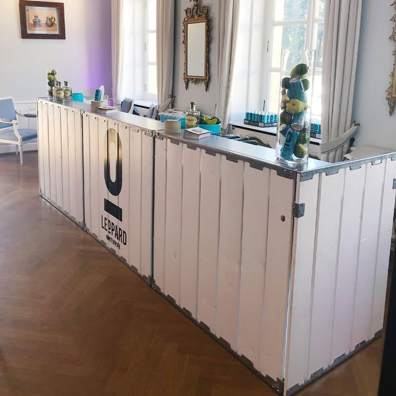 Portable bar counter made from repurposed shipping containers with Leopard logo for event hospitality.