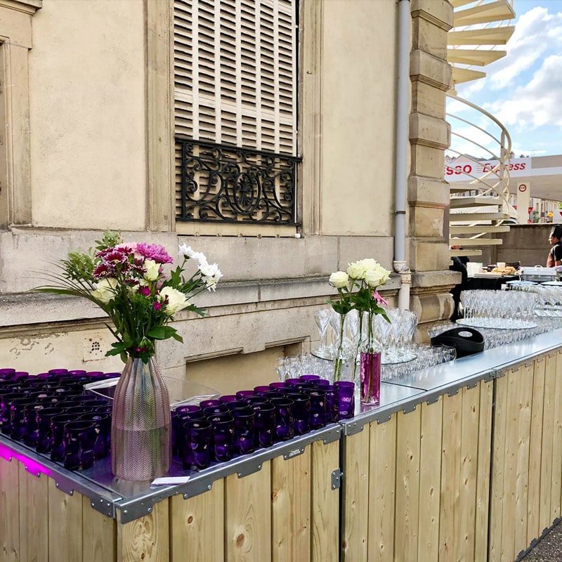Elegant roses in glass vases on a bar display for events and catering services by EJH Distribution.