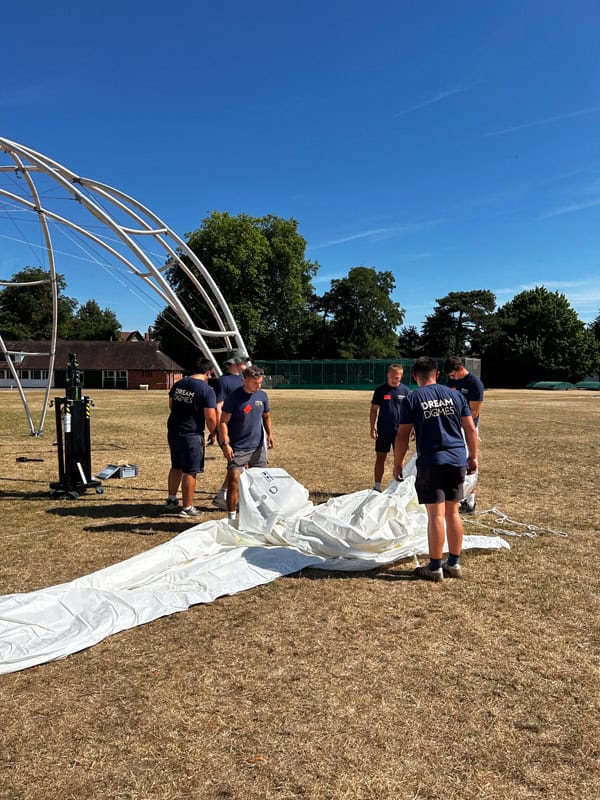 a group of people standing around a white tent