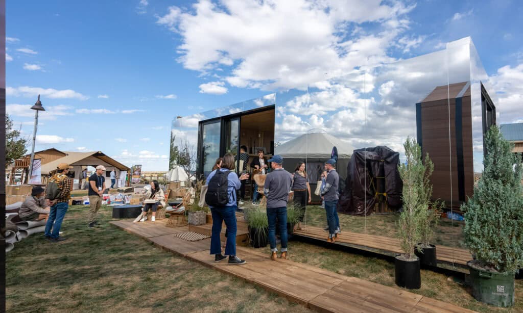 Modern tiny home exhibit at outdoor event showcasing innovative portable housing solutions and eco-friendly living spaces by EJH Distribution.
