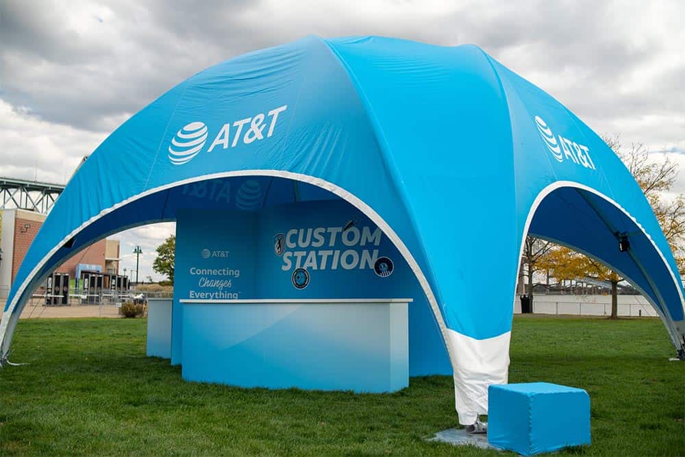 Blue AT&T branded tent with customer service station and signage.