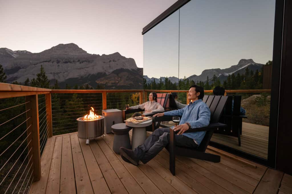 Relaxing outdoor mountain lodge balcony with seating and fire pit.