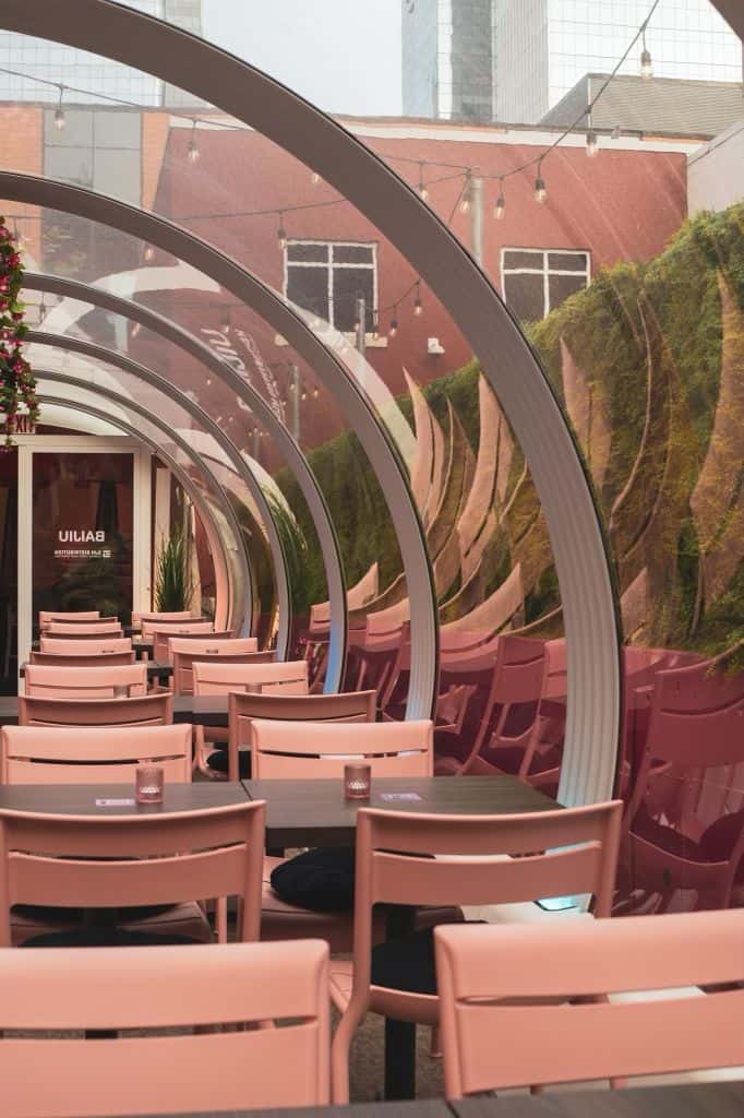Elegant patio setup with modern seating and stylish arches at Baijiu, a top Canadian restaurant. Perfect for outdoor dining and social gatherings in a vibrant urban setting.