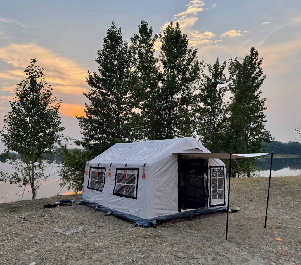 white inflatable tent set up by a river