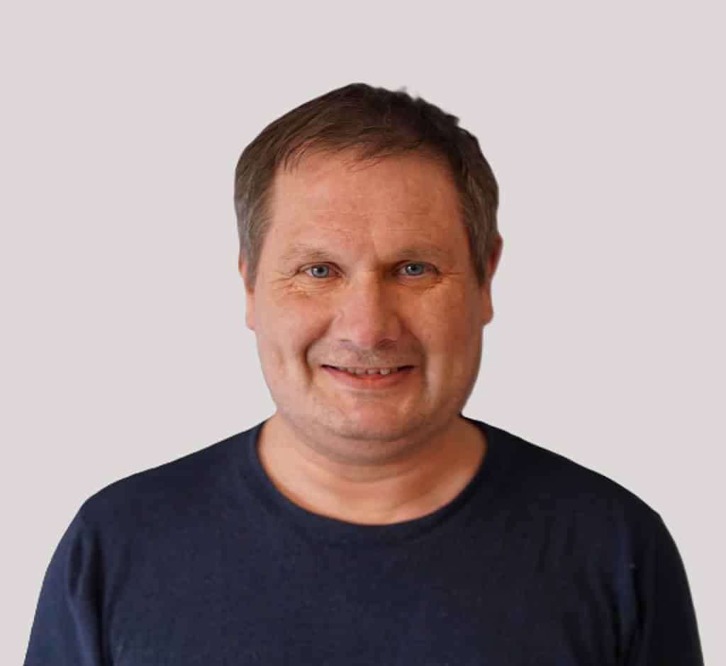 A man in a blue shirt smiling.