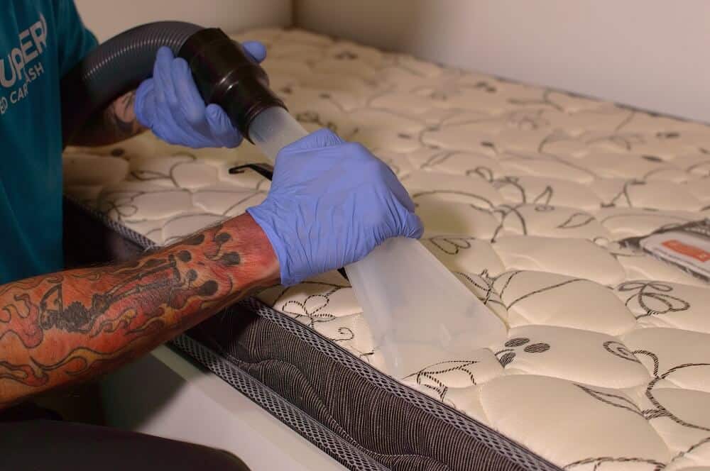 22 franquias baratas home office para 2026: opções para lucrar! Homem fazendo a limpeza de colchão com método Acquazero