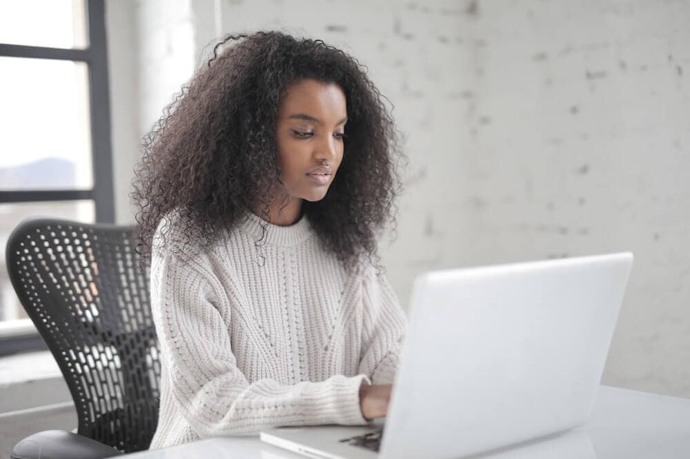 Franquias baratas online 2026 - guia rápido sobre o sistema Mulher séria trabalhando em um notebook branco. Ilustração do texto sobre franquias de tecnologia.