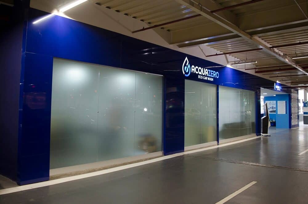 Vemos a fachada de uma loja da Acquazero em um estacionamento coberto (imagem ilustrativa). Texto: franquias brasileiras.