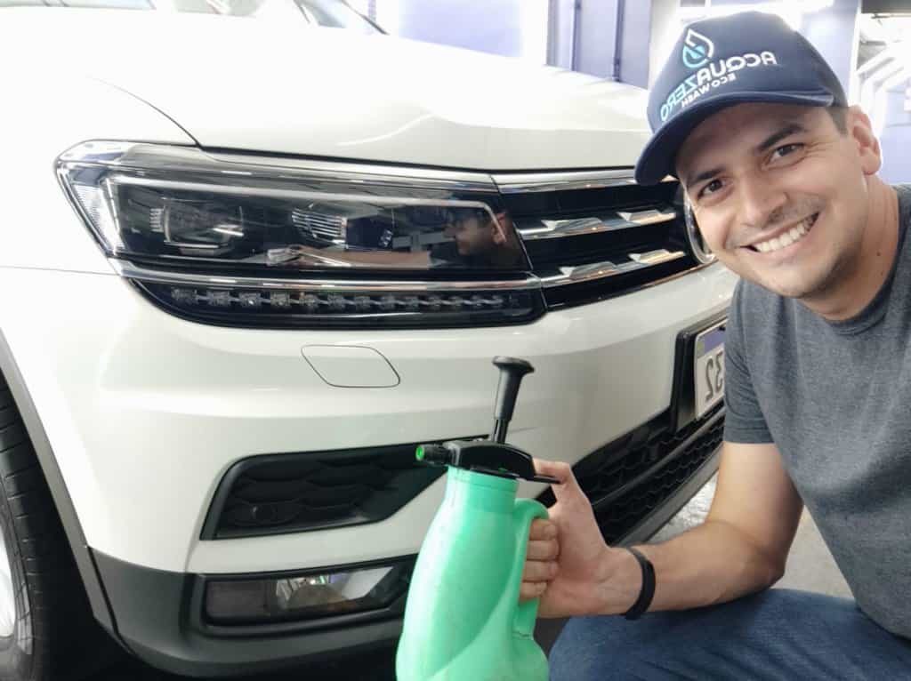 Marcos Freitas posa com borrifador em frente a um carro, como imagem ilustrativa do seu case de sucesso como franqueado Acquazero que abriu negócio na pandemia