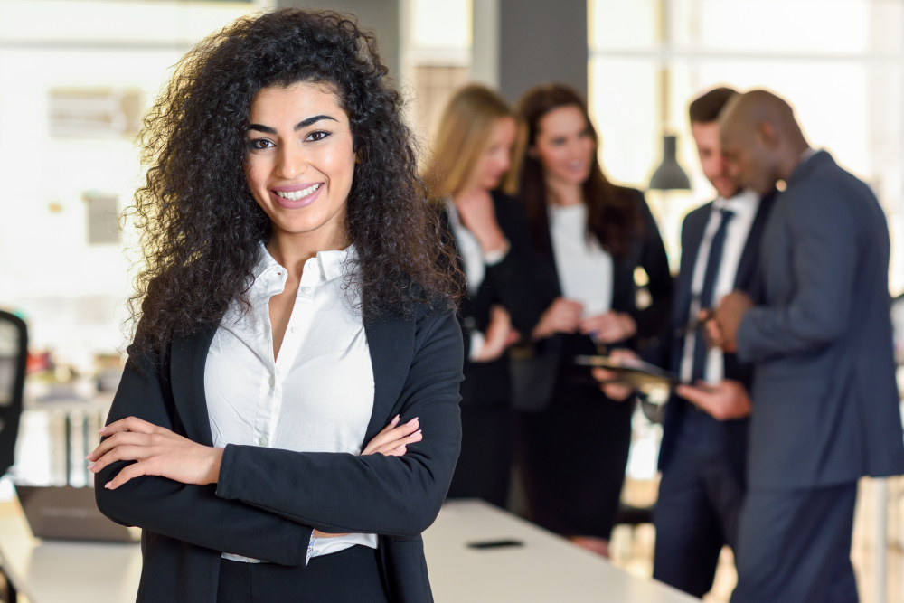 Mulher empreendedora. Ao fundo, grupo de pessoas reunidas. Ilustração do texto sobre de franquias de sucesso baixo investimento.