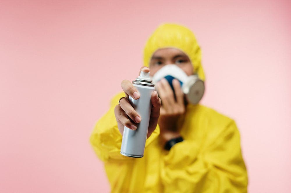 Homem usando macacão amarelo e máscara que protege de gás, segurando inseticida. Ilustração do texto sobre famosa franquia de exterminação de insetos.