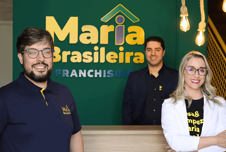 As 128 melhores franquias baratas em 2026 - veja a lista Diretoria da Maria Brasileira em frente à parede com logo da marca