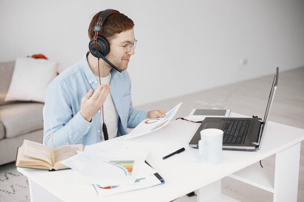 Homem sorridente, trabalhando com headset preto na cabeça. Ilustração do texto sobre empreendimento para iniciantes.