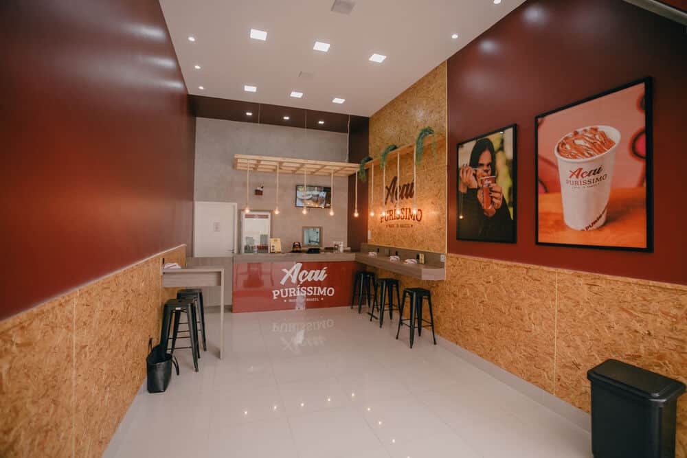 Interior da loja Açaí Puríssimo, com paredes vermelhas e bancos à direita. Imagem ilustrativa do texto Franquia Açaí Puríssimo