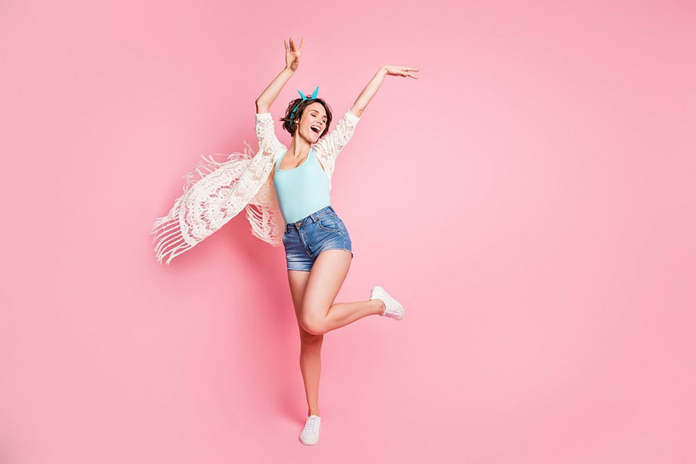 mulher de blusa e shorts dançando sob fundo rosa claro ilustração de franquias rentáveis