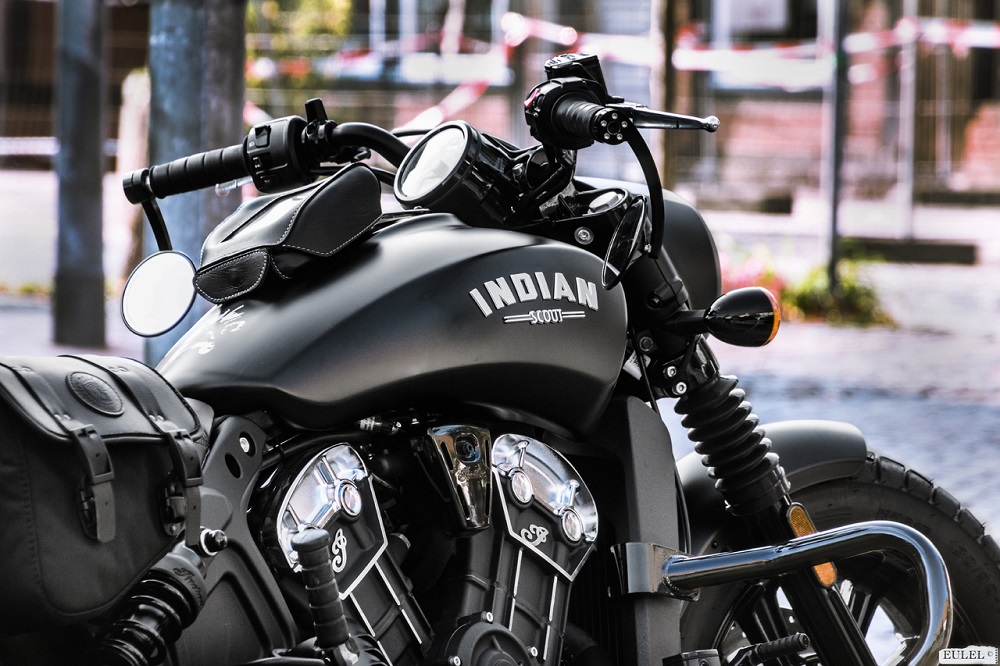 Imagem de uma moto com a estrutura preta e um escrito em branco "Indian". Imagem ilustrativa texto franquia de motopeças.