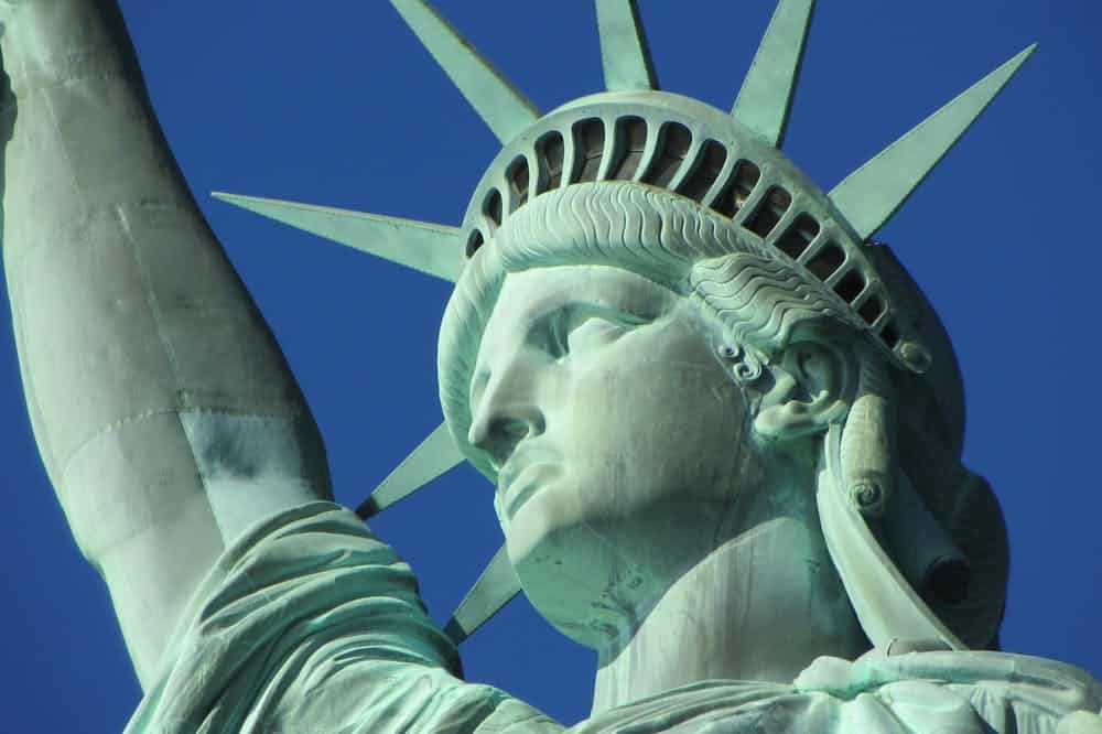 Estátua da Liberdade destacada no céu azul. Ilustração do texto sobre como abrir uma franquia nos Estados Unidos.